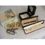 A small carton of costume jewellery items to include Isle of Wight Pearl necklace in original box,