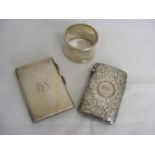 A silver card case together with another and a silver napkin ring