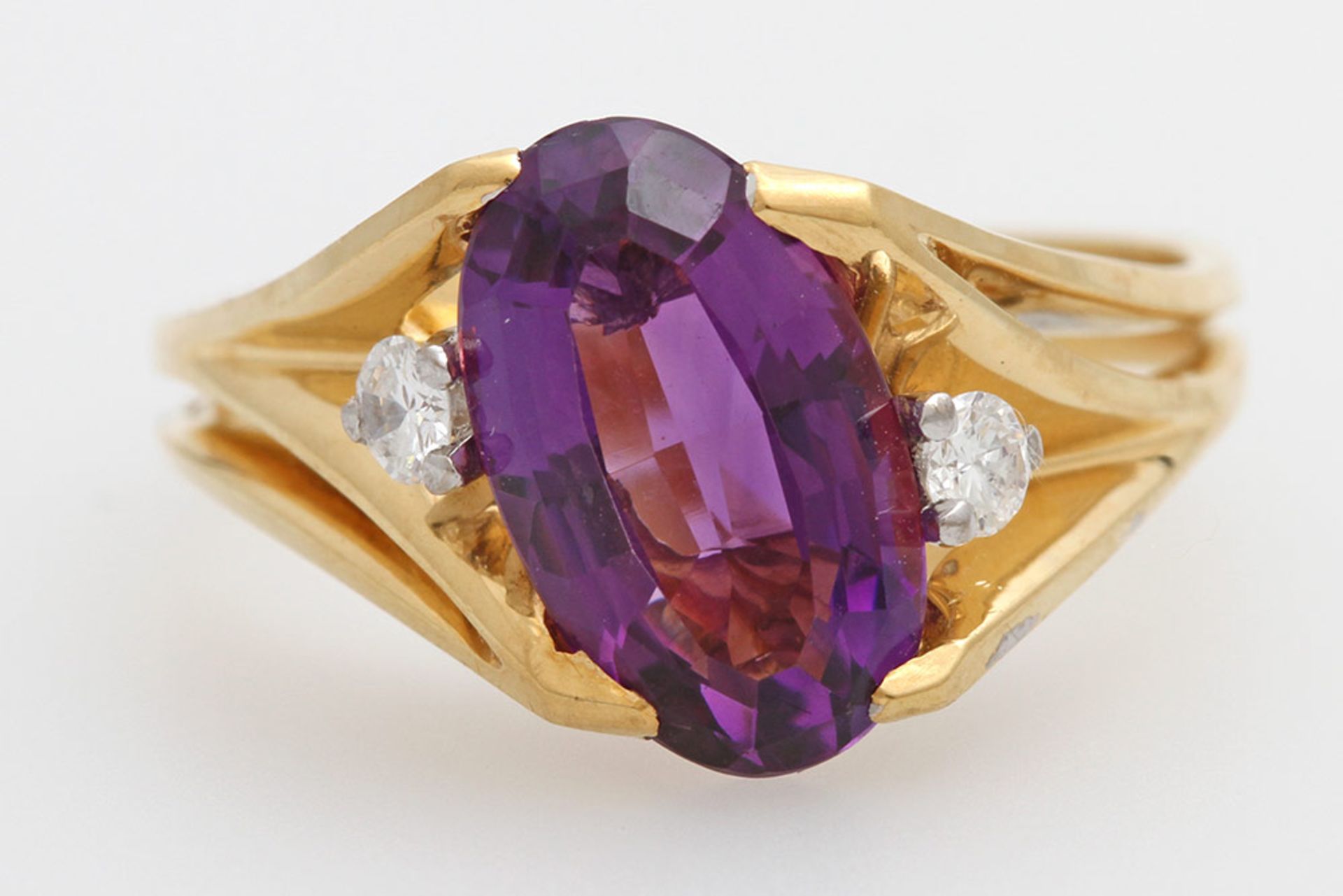 Damenring mit einem oval facettierten Amethyst und 2 Brill. zus. ca. 0,12ct., Weiß/ VS. GG 18K, W: