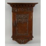 Arts & Crafts carved oak wall cupboard with floral decoration carved in relief, height 53cm, width