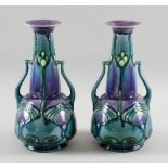 A pair of Minton Secessionist twin-handled vases, in blues and mauve marked to underside Minton