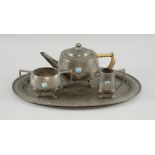 Hammered pewter four piece tea service, with Ruskin style cabochons, marked Gladwin