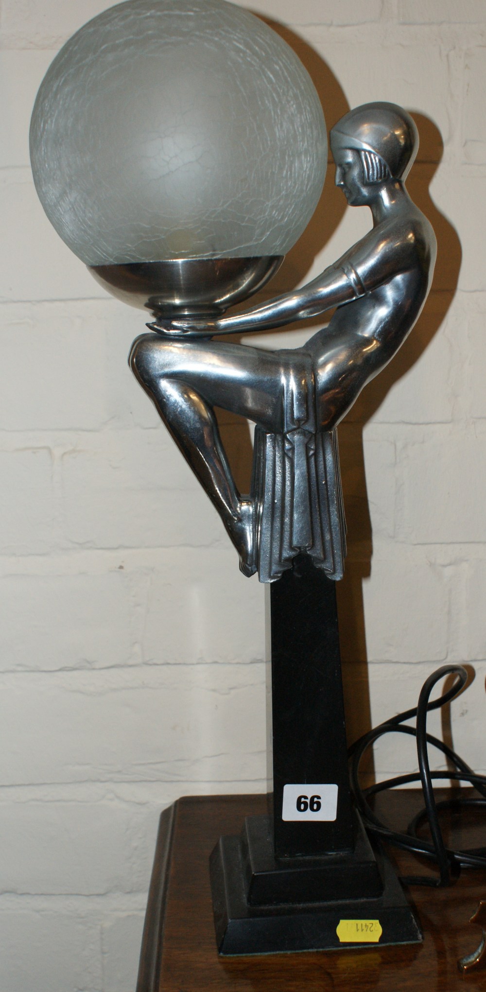 Art Deco style table lamp in the form of a semi-naked dancing girl seated holding a large crackle