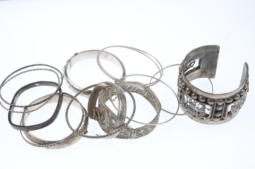 A selection of bangles. To include a hinged filigree bangle with flower detail and an - Image 2 of 2