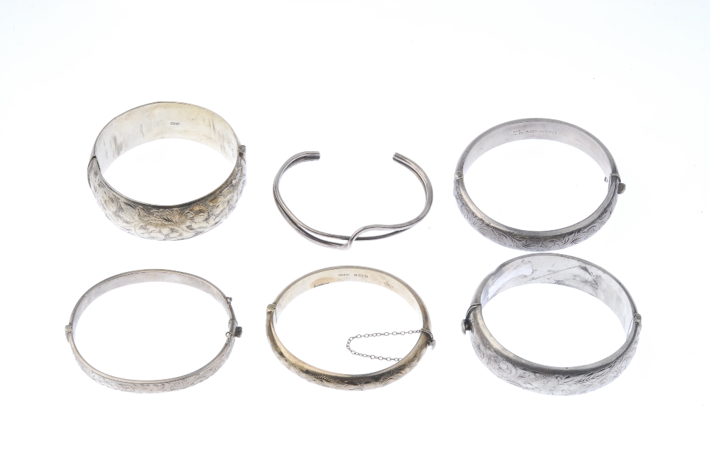 A selection of silver bangles. The first designed as a wide hinged silver bangle with foliate - Image 2 of 2