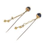 A pair of banded agate bead hatpins. Each designed as a banded agate sphere, with floral terminal,