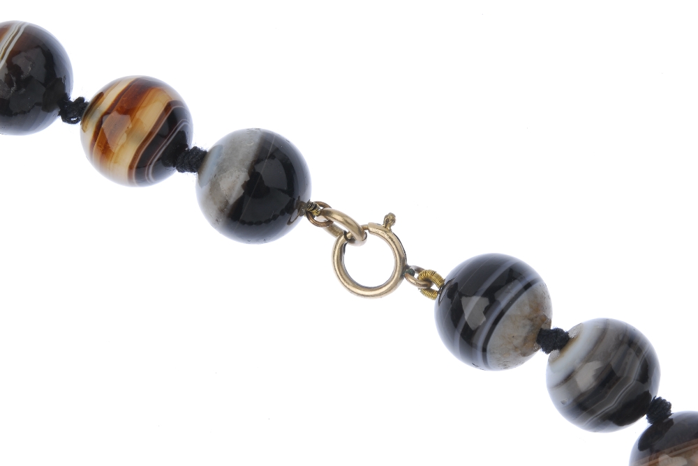 An agate bead necklace. Comprising a series of twenty-three graduated spherical beads, to the - Image 2 of 3
