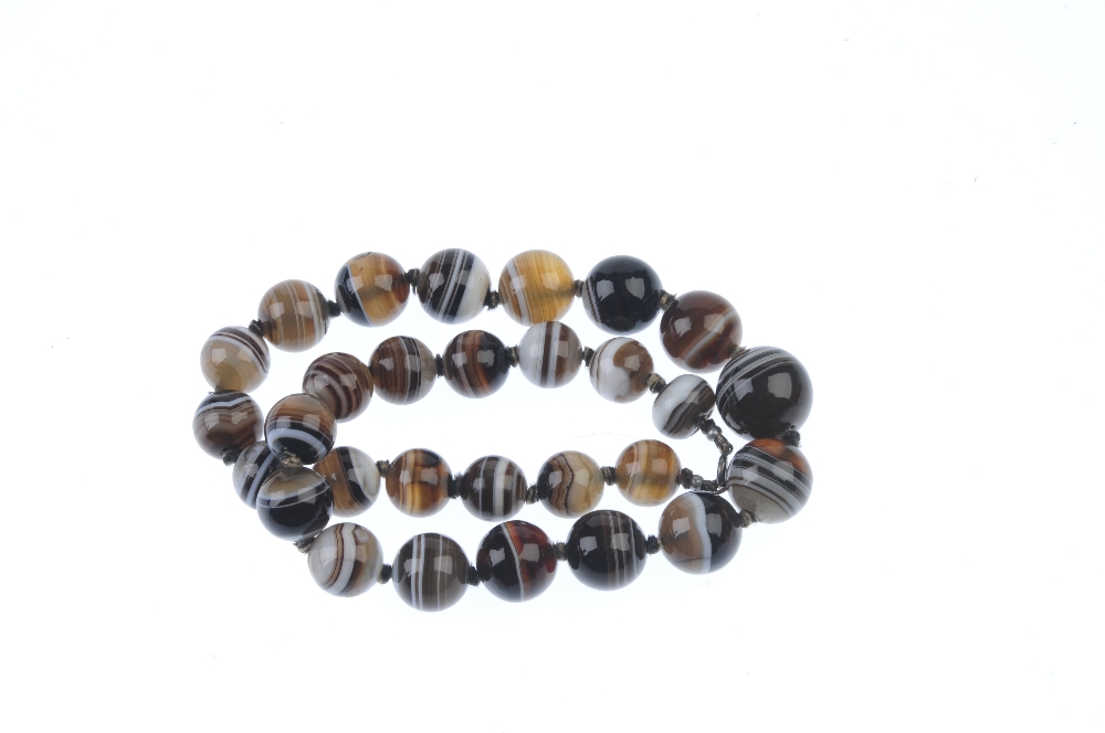An agate bead necklace. Comprising a series of twenty-nine graduated spherical agate beads, to the - Image 2 of 2