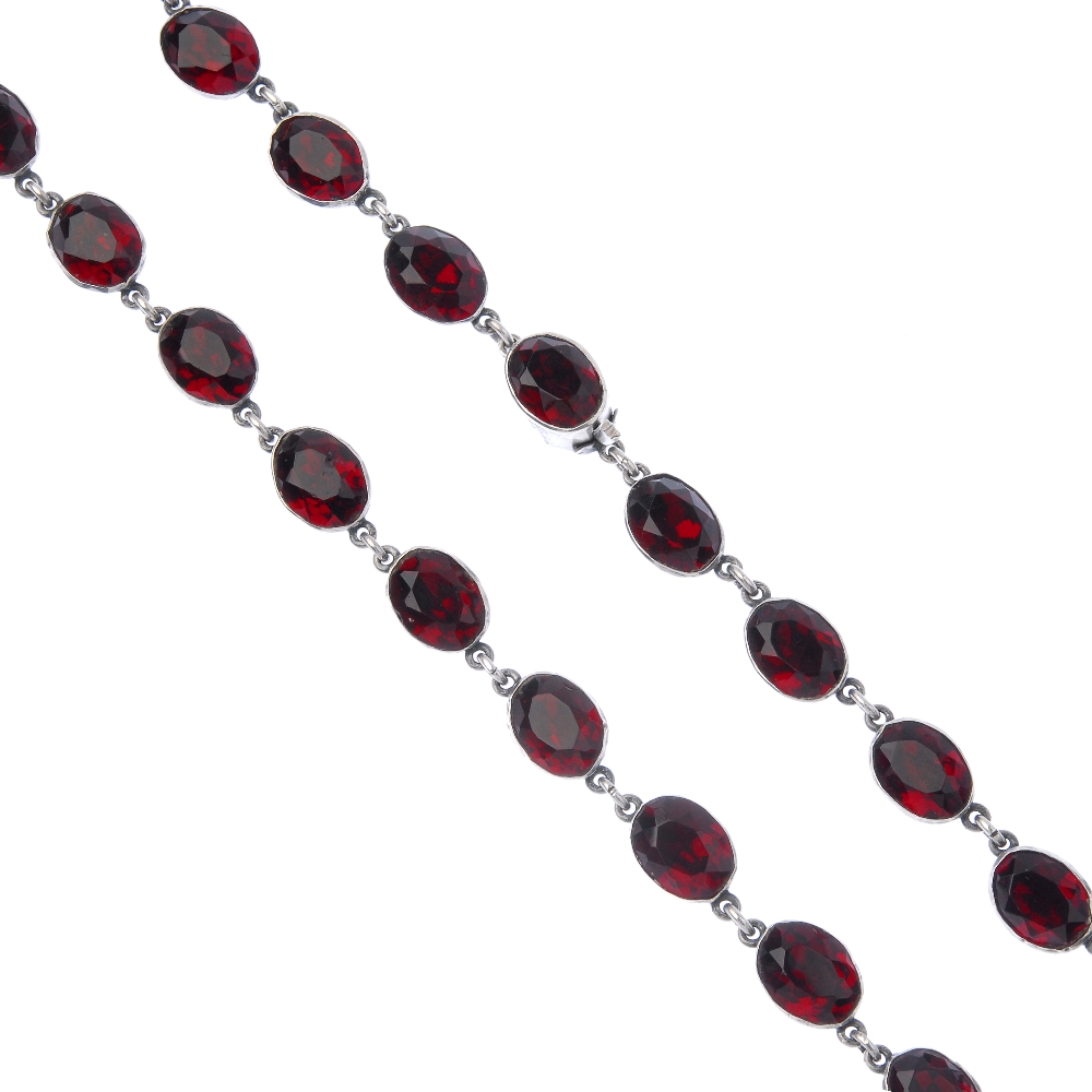A paste necklace. Designed as a series of oval-shape red paste collets, to the similarly-designed