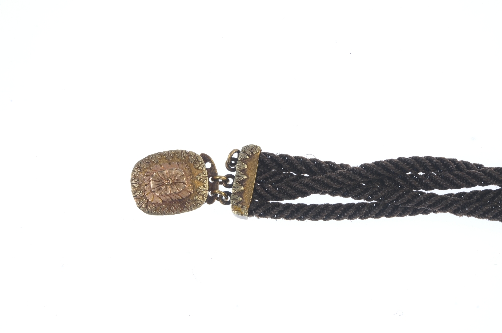 A late Victorian woven memorial hair bracelet. Comprising four strands of woven hair, to the foliate - Image 2 of 3