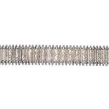 A late Victorian silver bracelet. Designed as a series of scroll engraved rectangular-shape links,
