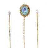 A set of three stickpins. To include a gold stickpin with oval-shape glass panel painted with a
