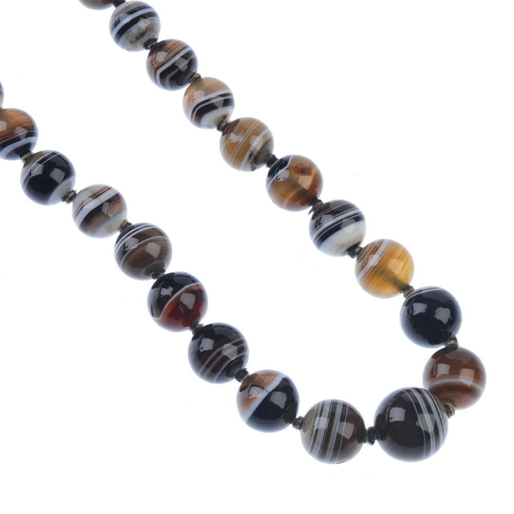 An agate bead necklace. Comprising a series of twenty-nine graduated spherical agate beads, to the