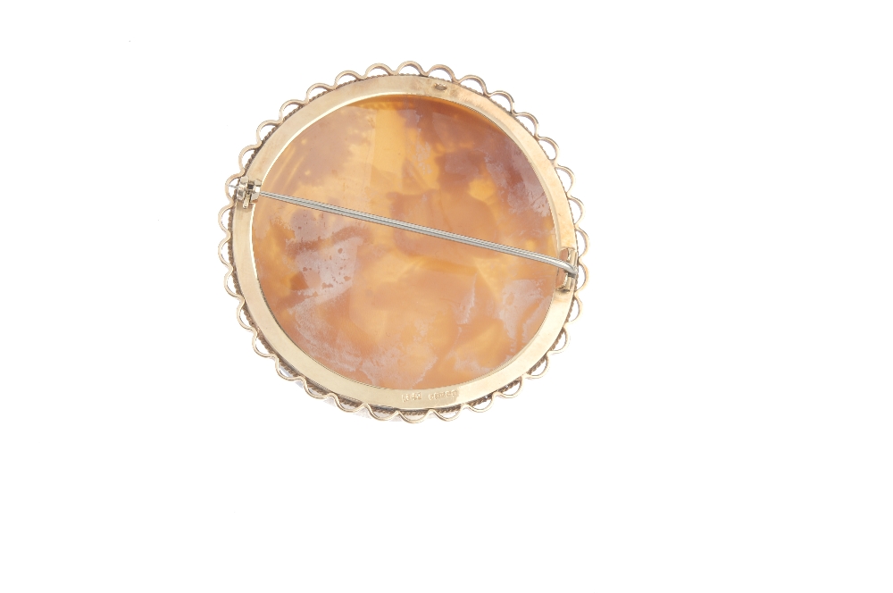 A 9ct gold cameo brooch. Of circular outline, the cameo depicting a winged lady playing a lyre for - Image 2 of 2