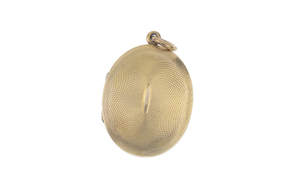 A late Victorian locket. The gold front and back locket is of oval outline with engine turned - Image 2 of 3