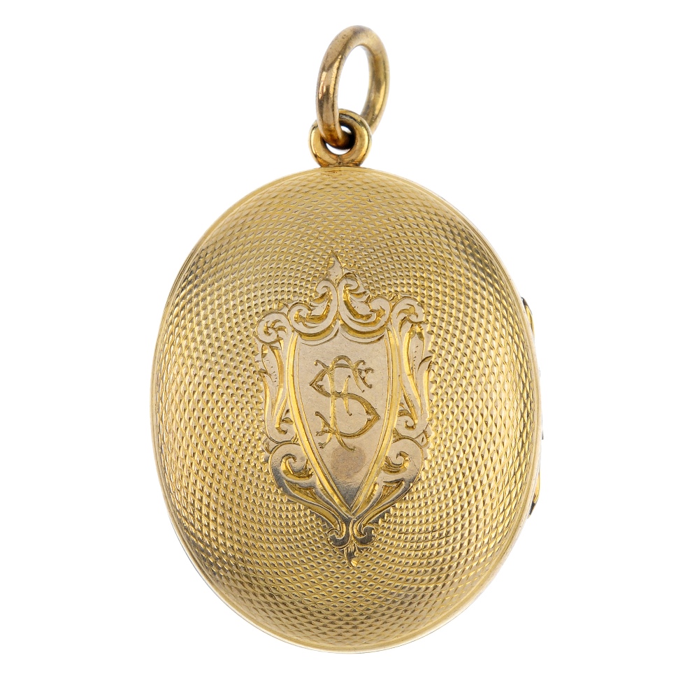 A late Victorian locket. The gold front and back locket is of oval outline with engine turned