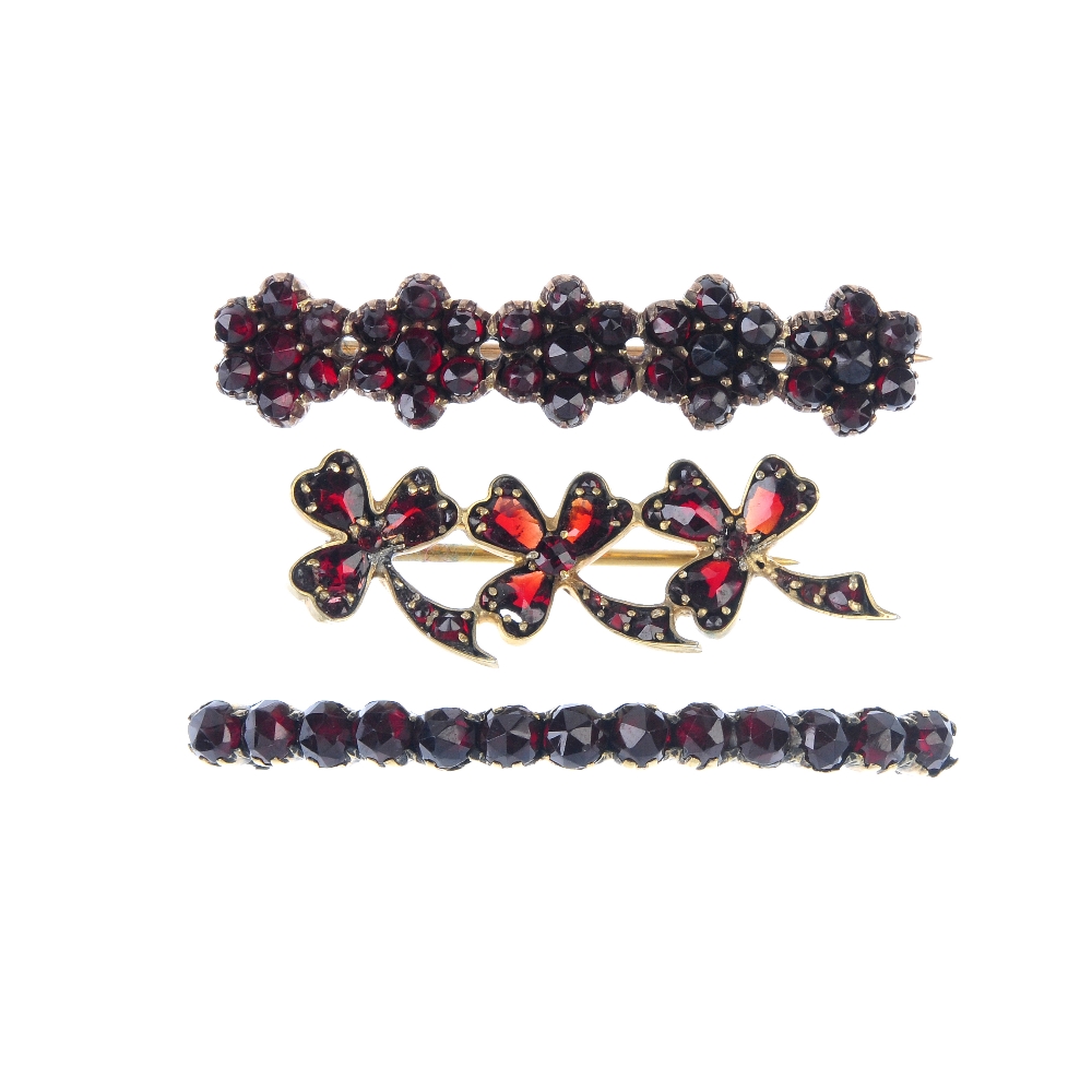 A selection of three garnet and red paste brooches. To include a three-leaf clover line brooch, a