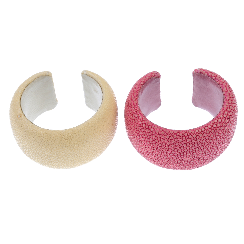 Two stingray cuffs. The two cuffs, one of pale yellow, the other of pinkish-red, to the leather