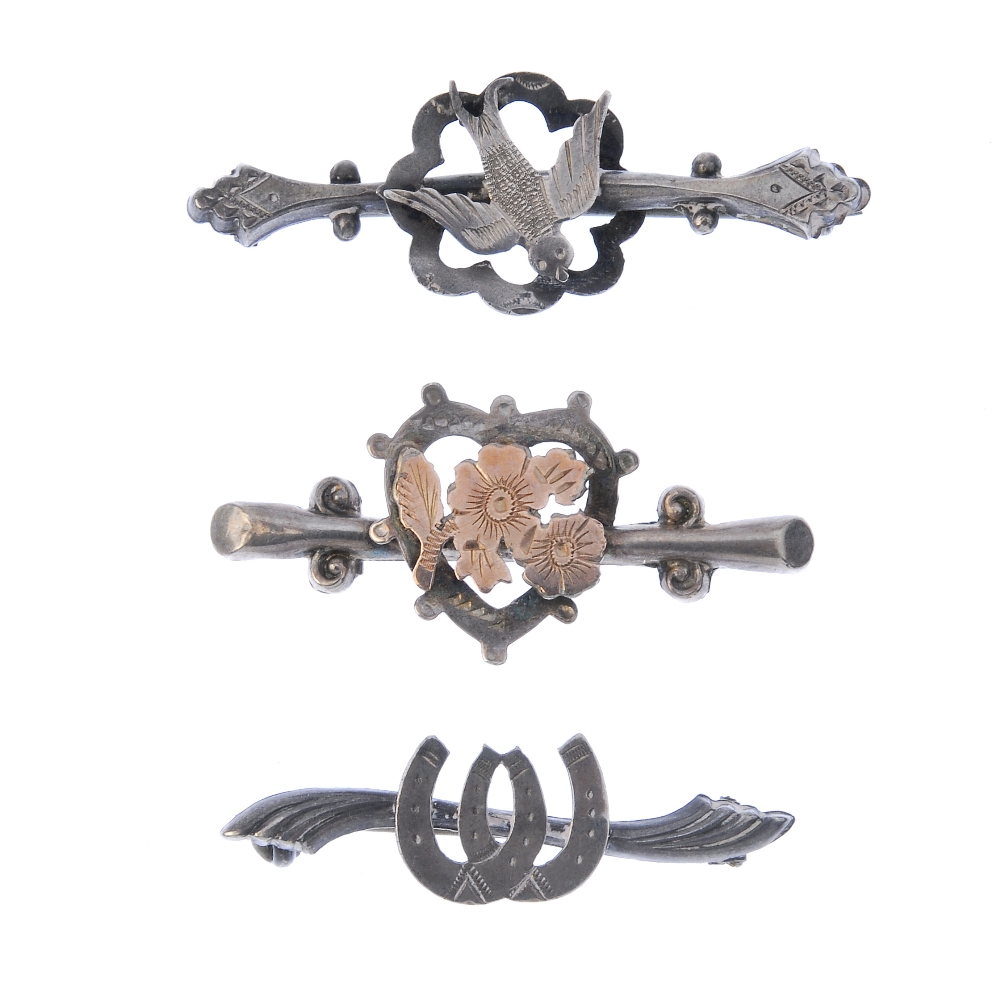 Five Edwardian and Georgian silver brooches. To include one designed as two horseshoes to the