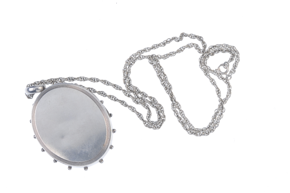 A late Victorian silver locket. The chain suspending a locket of oval outline, with castellated - Image 2 of 2