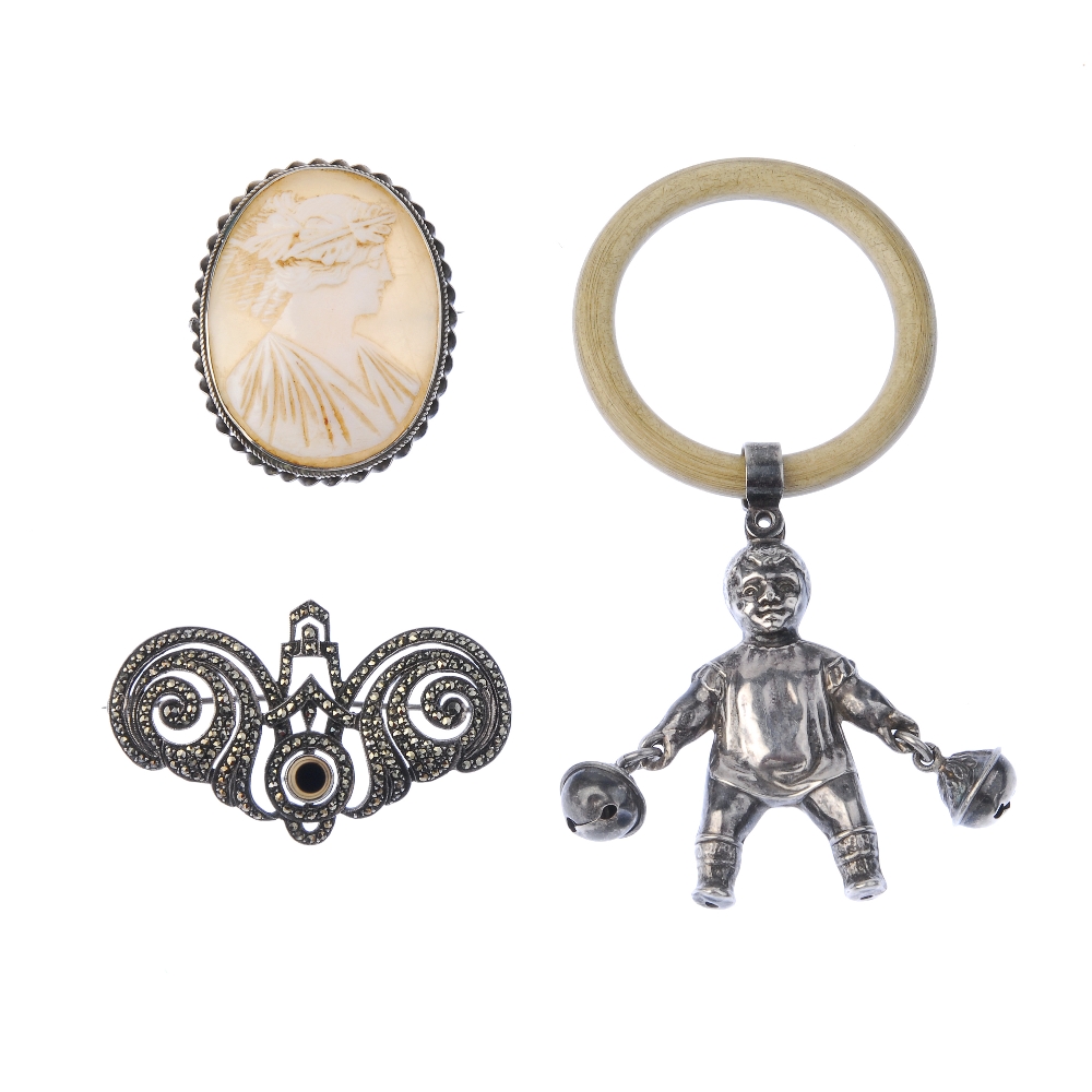 A selection of silver items. To include a child's rattle, designed as a baby carrying a bell in
