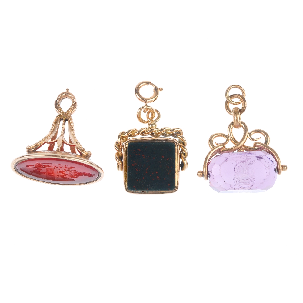 Three fobs. The first an oval-shape carnelian with crest intaglio, to the beaded pedestal,
