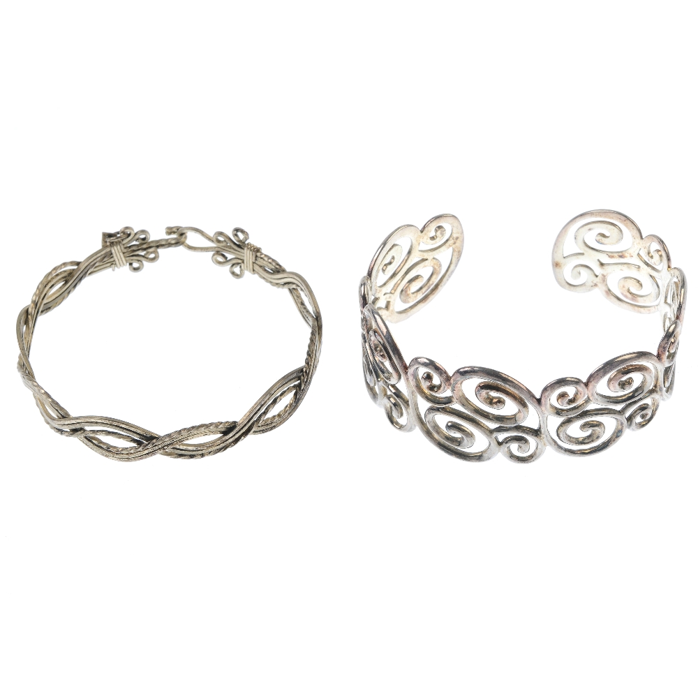A selection of silver and white metal bangles. To include a square profile bangle, a hinged silver