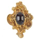A late 19th century gold and garnet pendant. The oval cabochon garnet claw set to the wirework and