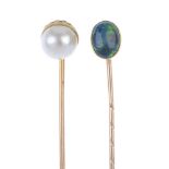 Four stickpins. The first with an oval-shape head set with an opal cabochon, the second a cultured