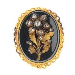 A late Victorian gold onyx and diamond brooch. Of oval outline, the onyx panel with applied flower