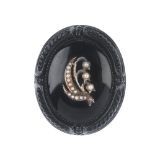 A late Victorian memorial jet and split pearl brooch. Of oval outline, the outer edge with carved