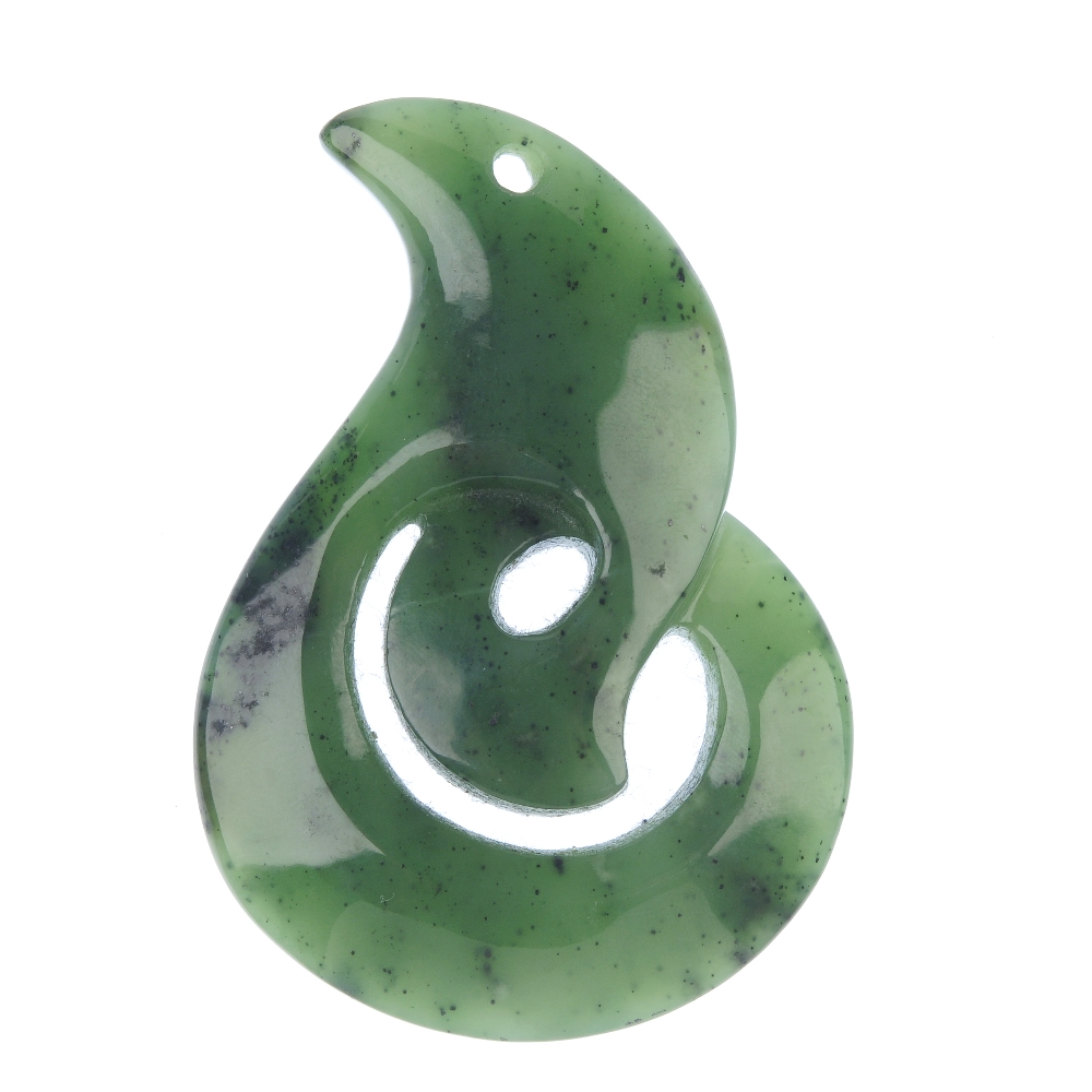 A carved Maori jade koru pendant. The koru representing an unfurling fern leaf and symbolising new