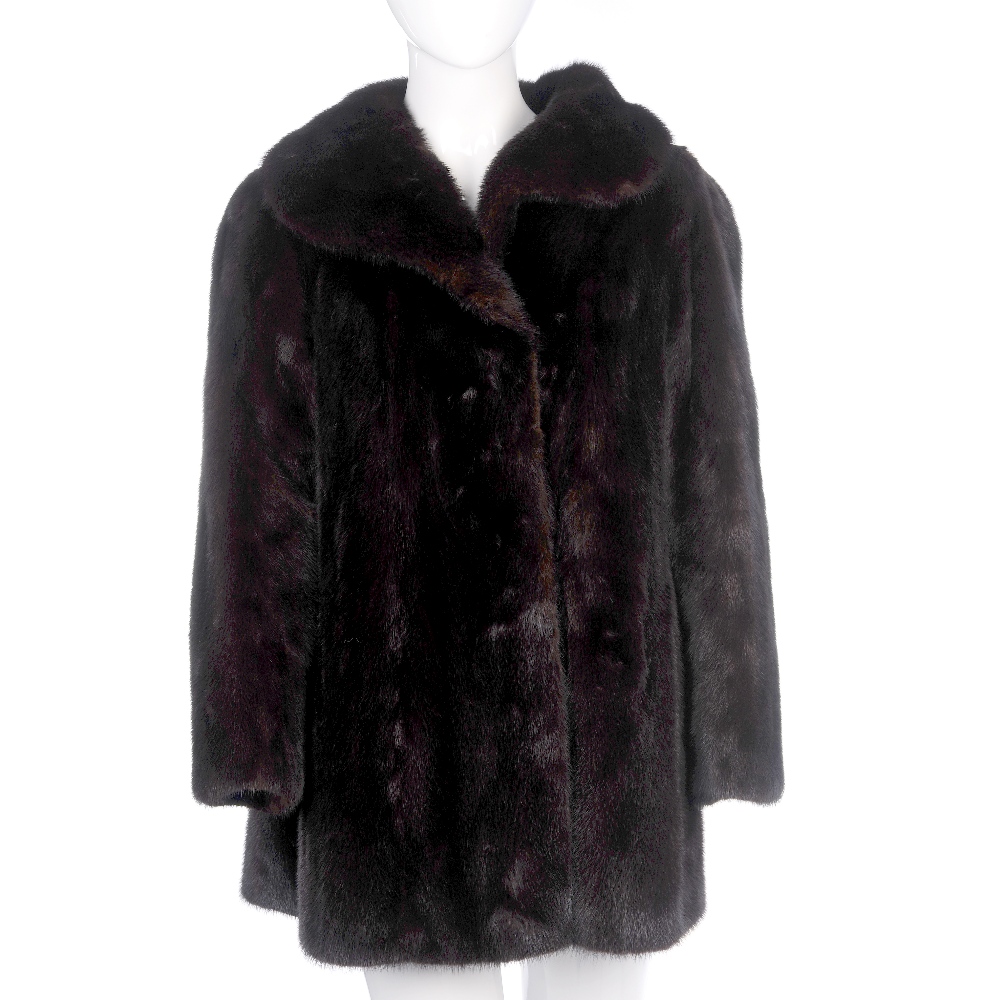 A three-quarter length dark ranch mink coat. Designed with a lapel collar, hook and eye