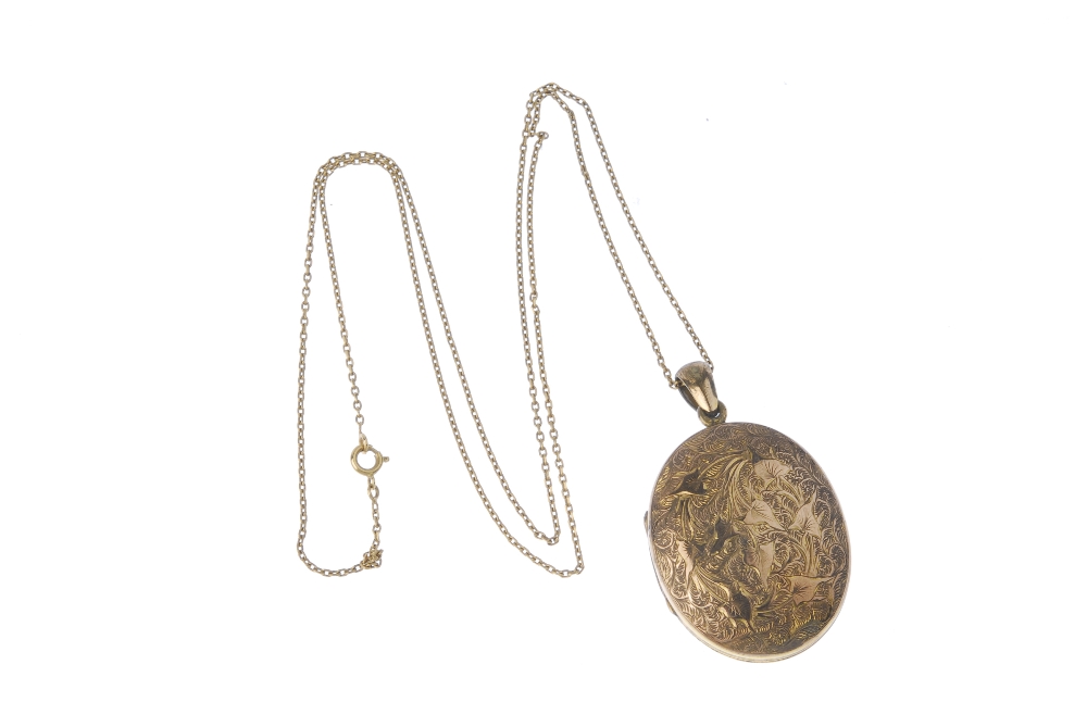 A gold front and back locket. Of oval-outline, the front and back with ivy engraving, opening to - Image 2 of 2
