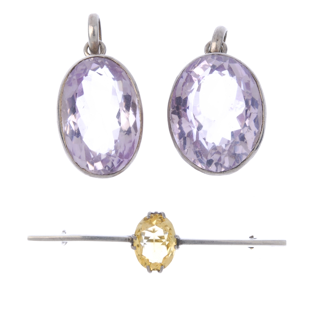 Two amethyst pendants and a citrine bar brooch. To include two oval-shape amethyst pendants and an