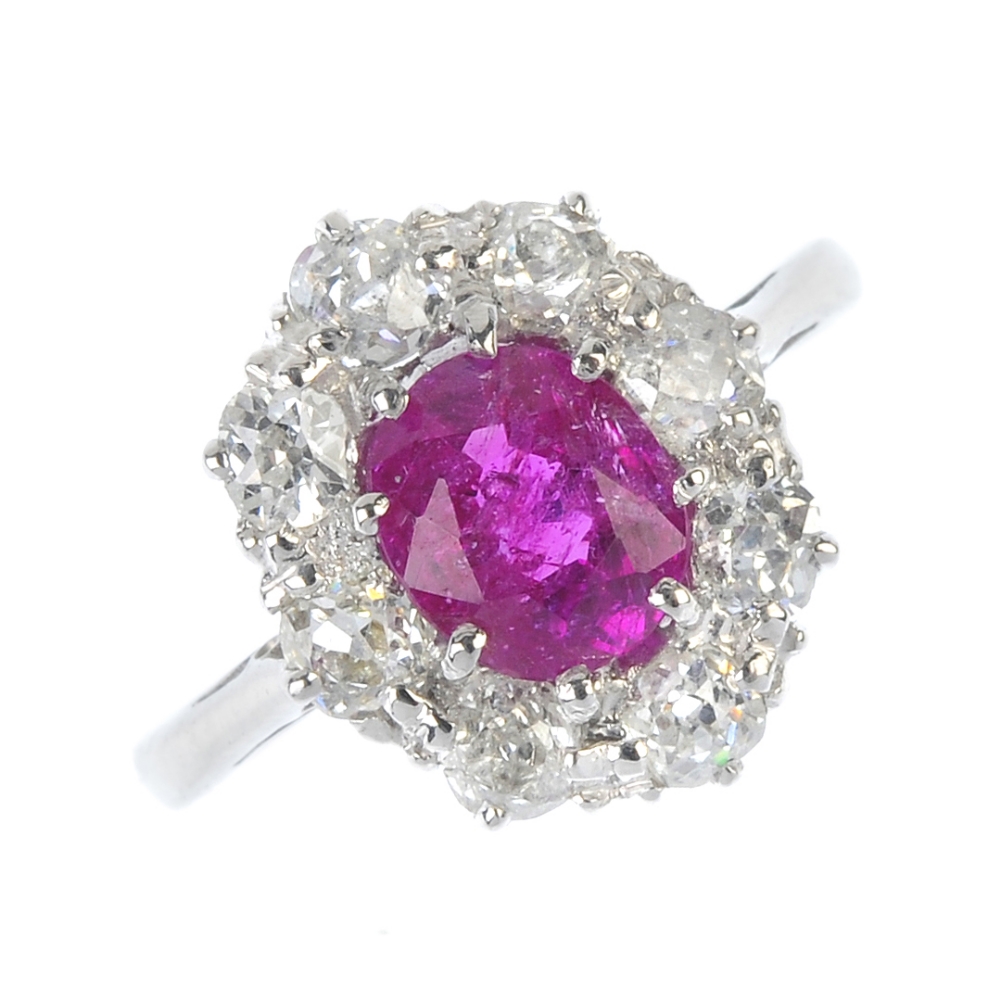 A Burmese ruby and diamond ring. The oval-shape ruby, weighing 1.35cts, within an old-cut diamond