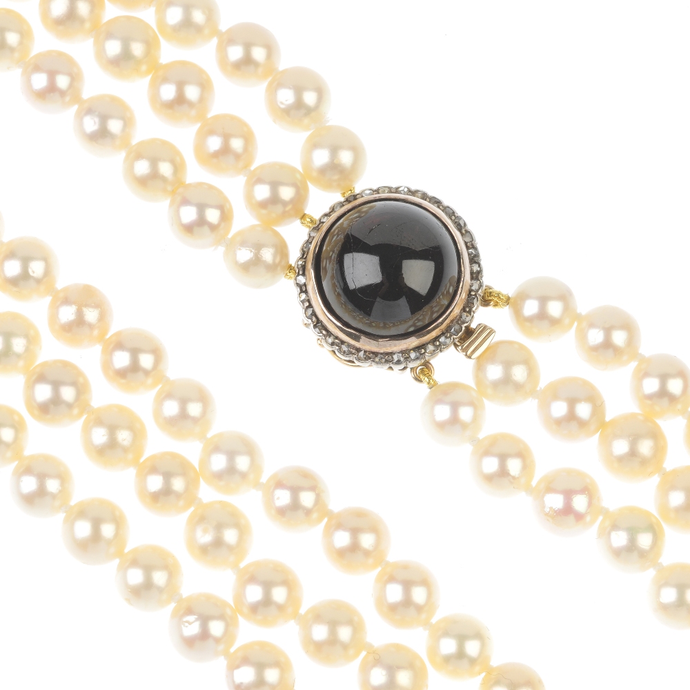 A cultured pearl three-row necklace, with garnet and rose-cut diamond clasp. The cultured pearls,