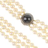 A cultured pearl three-row necklace, with garnet and rose-cut diamond clasp. The cultured pearls,