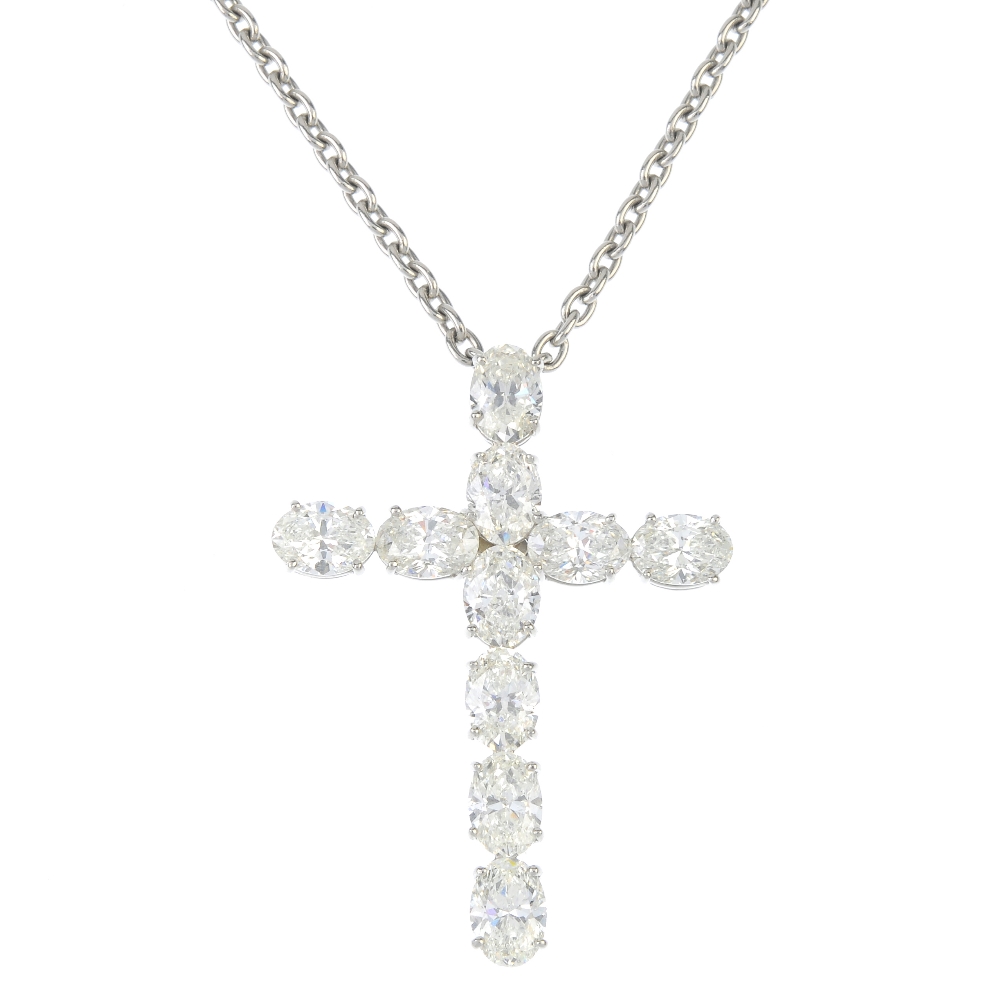 A diamond cross pendant. Designed as a series of oval-shape diamonds, suspended from a belcher-