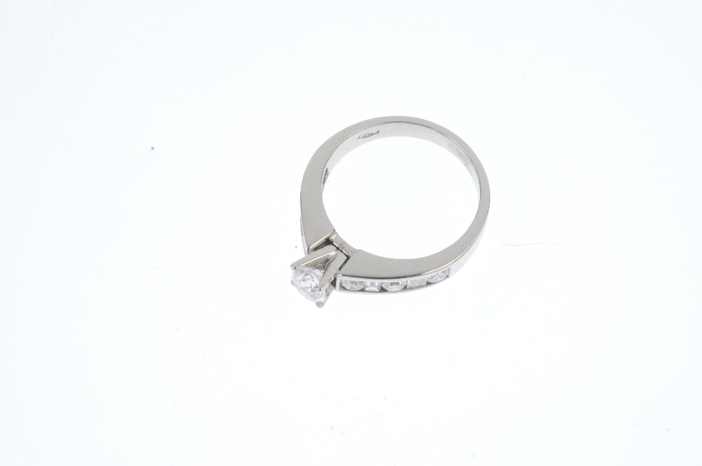 A diamond single-stone ring. The brilliant-cut diamond, to the baguette and brilliant-cut diamond - Image 2 of 3