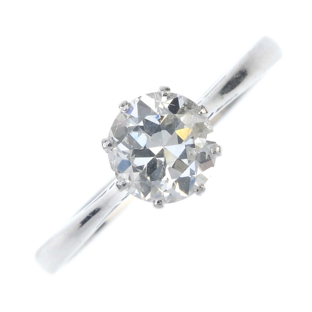 A diamond single-stone ring. The circular-cut diamond, to the tapered shoulders and plain band.