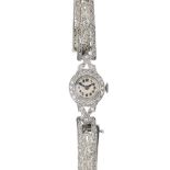 An early 20th century platinum diamond cocktail watch. The circular-shape cream dial, with black