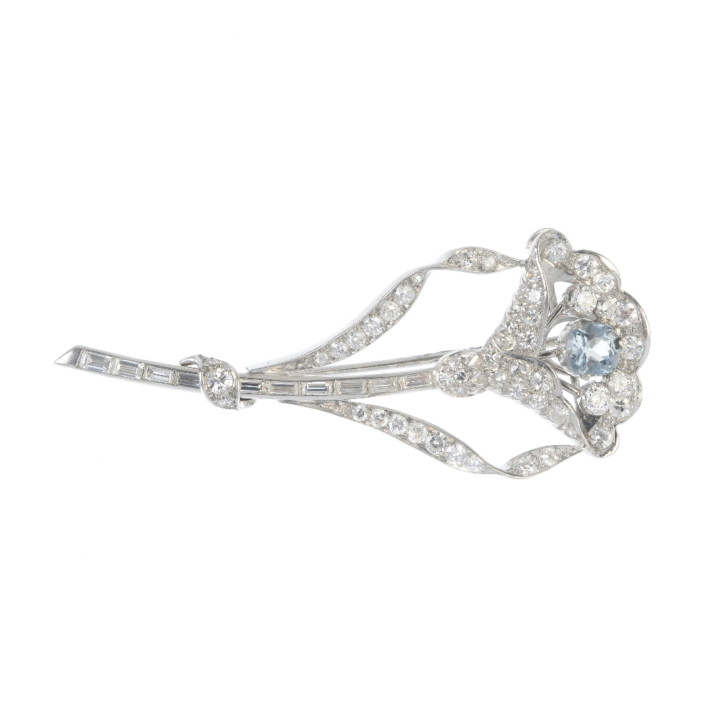 A mid 20th century aquamarine and diamond flower brooch. The cushion-shape aquamarine and