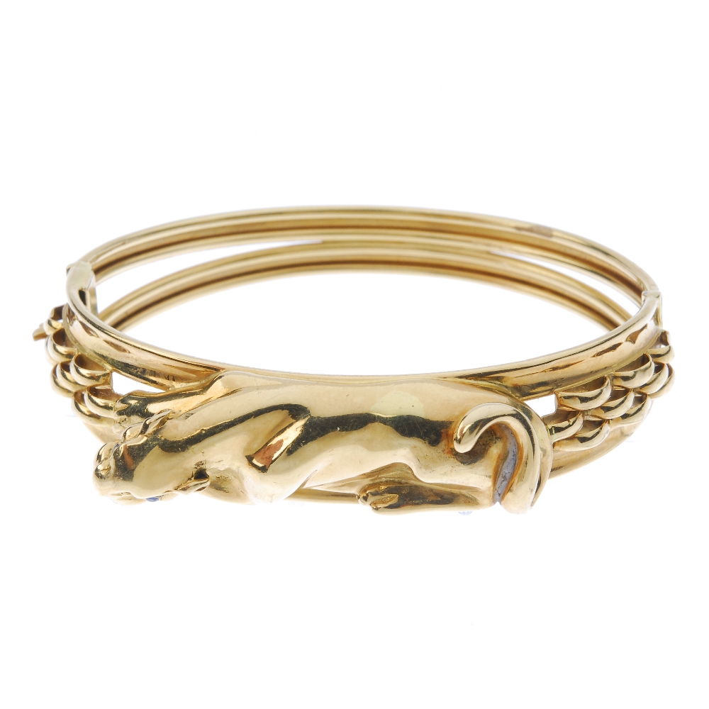 A panther bangle. Designed as a lying panther, with sapphire eyes, to the brick motif sides and