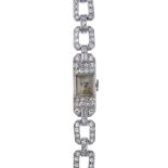 A mid 20th century platinum diamond cocktail watch. The rectangular-shape cream dial with Arabic