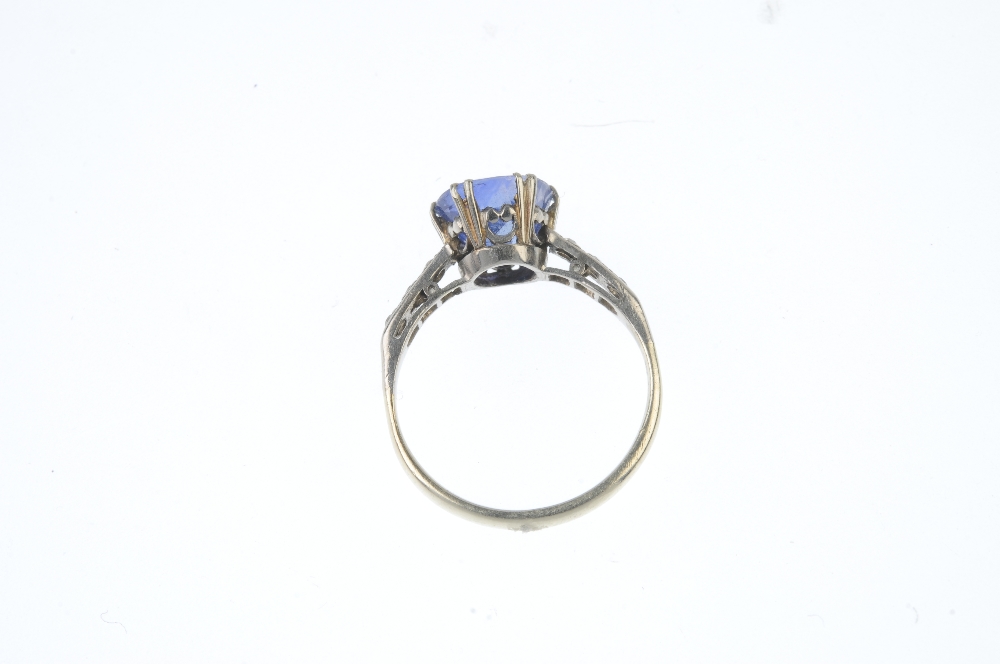 A sapphire and diamond ring. The circular-shape sapphire, with single-cut diamond line shoulders, to - Image 3 of 3