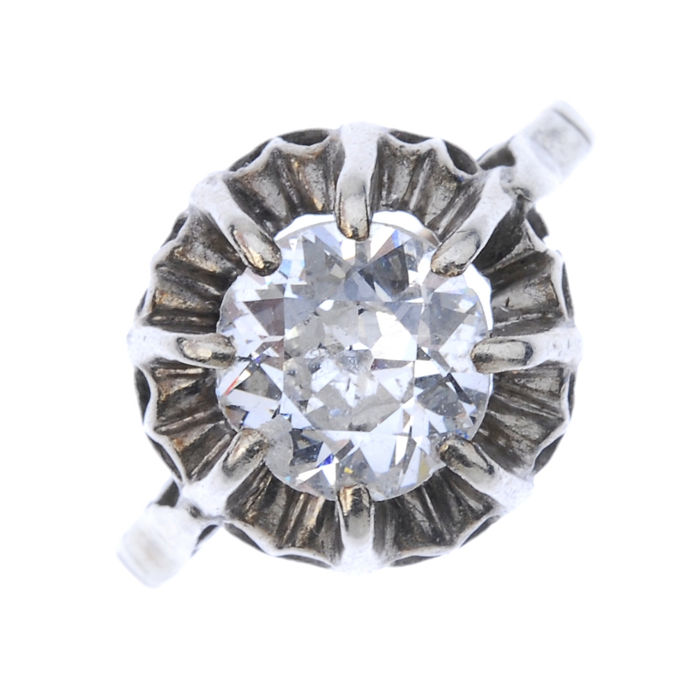 A mid 20th century diamond single-stone ring. The old-cut diamond, within an undulating surround, to