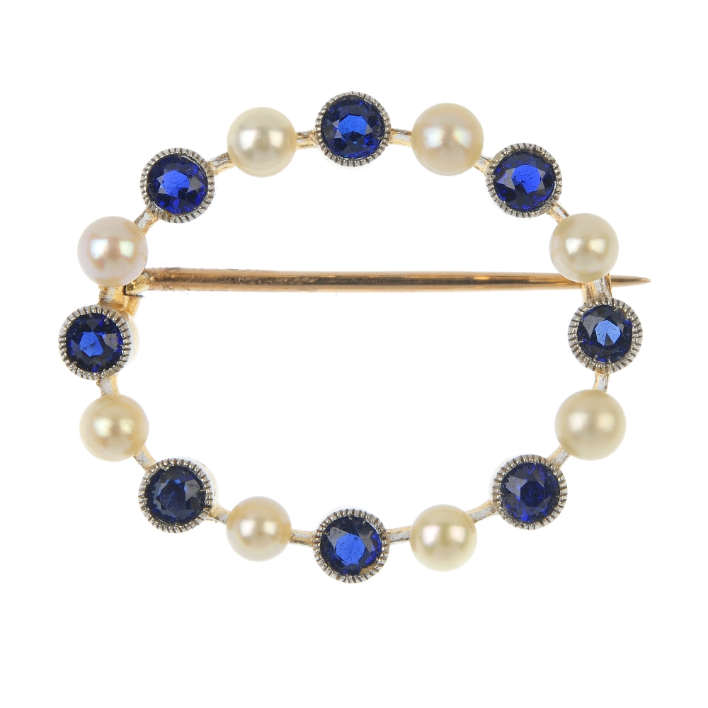 An early 20th century gold sapphire and seed pearl wreath brooch. Comprising an alternating