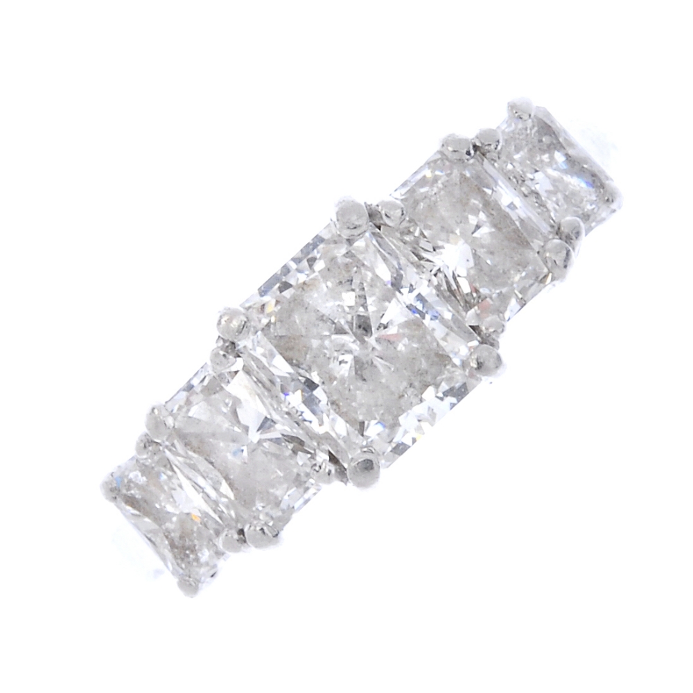 A platinum diamond five-stone ring. The rectangular brilliant-cut diamond, weighing 1.02cts, with