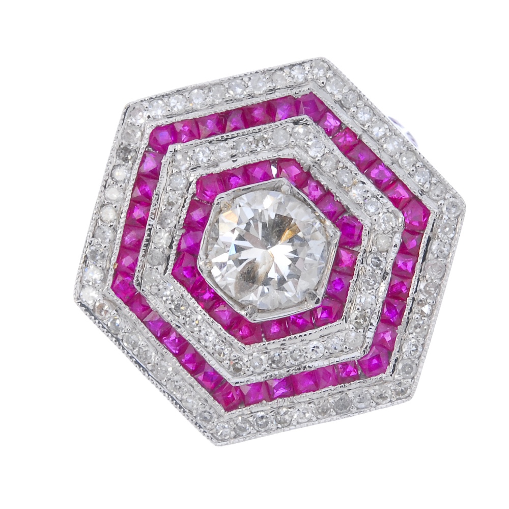 An 18ct gold diamond and ruby ring. Of hexagonal outline, the brilliant-cut diamond, within an
